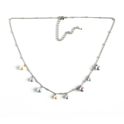 Faux pearl charms necklace with extender chain on white background.