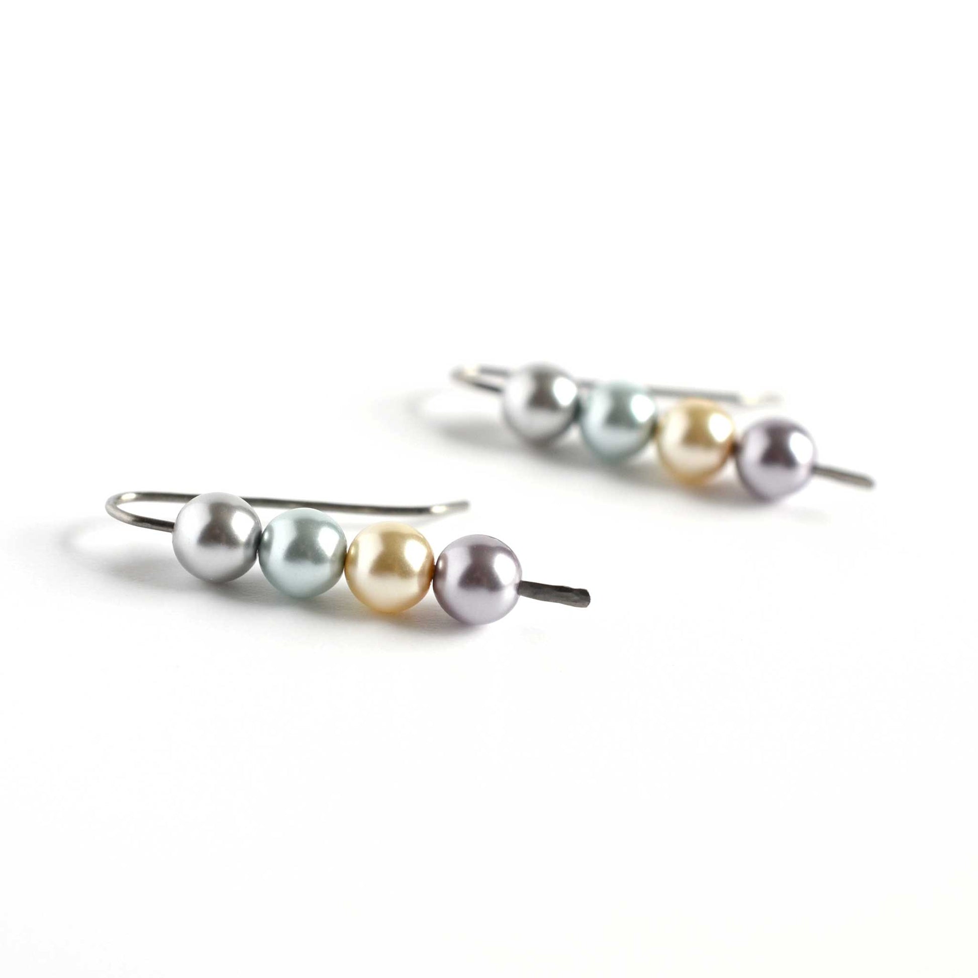 Side view of faux pearl stack earrings on white background