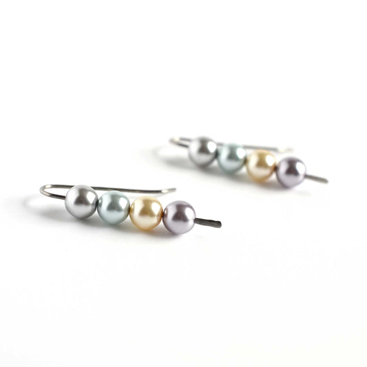 Side view of faux pearl stack earrings on white background