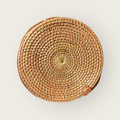 Round woven rattan bag with a brand label on a light gray background
