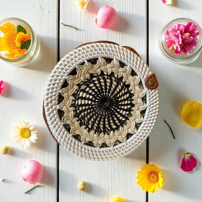 Woven bag with a decorative pattern on a wooden surface with flowers around