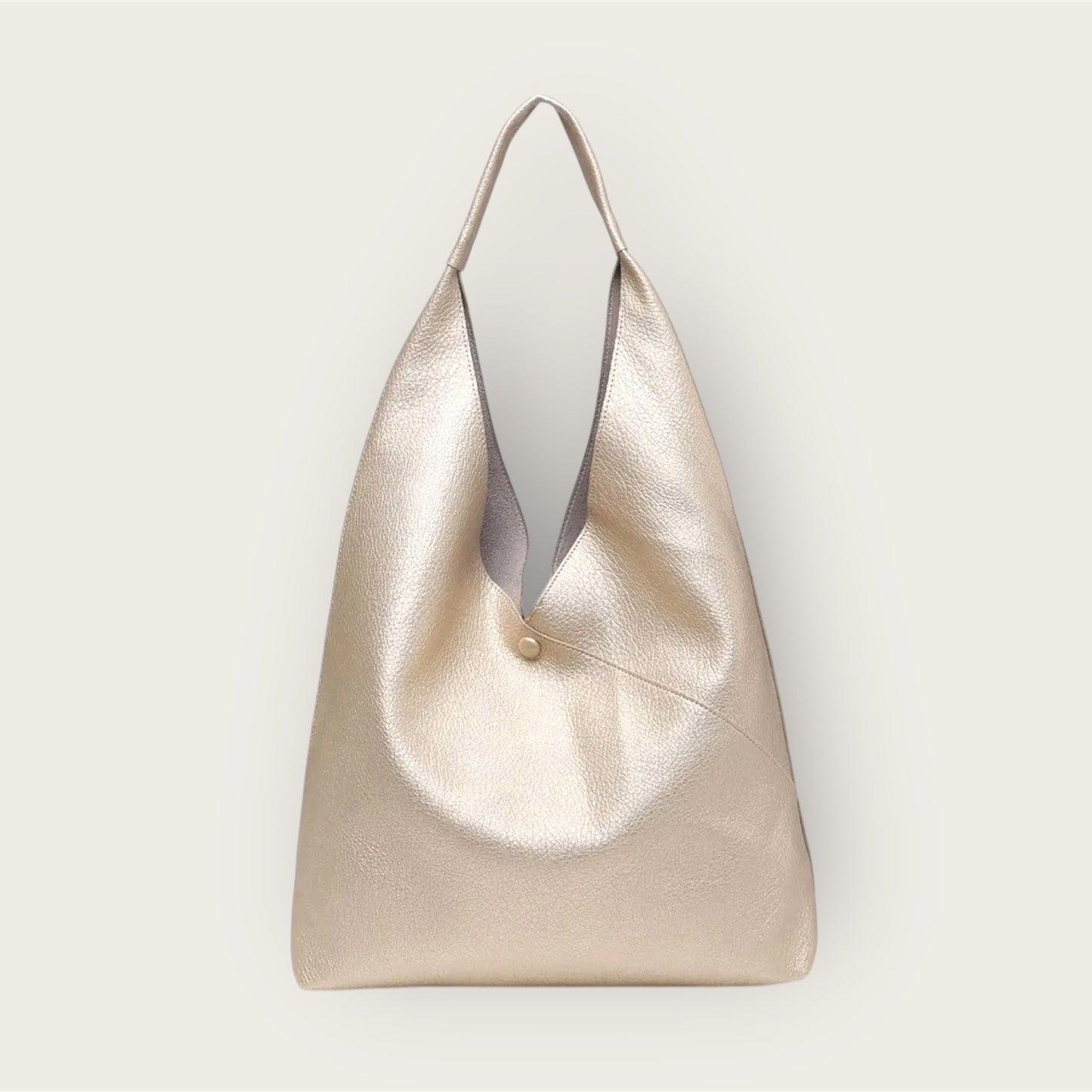 Gold handbag with a subtle texture on a light gray background