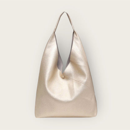 Gold handbag with a subtle texture on a light gray background