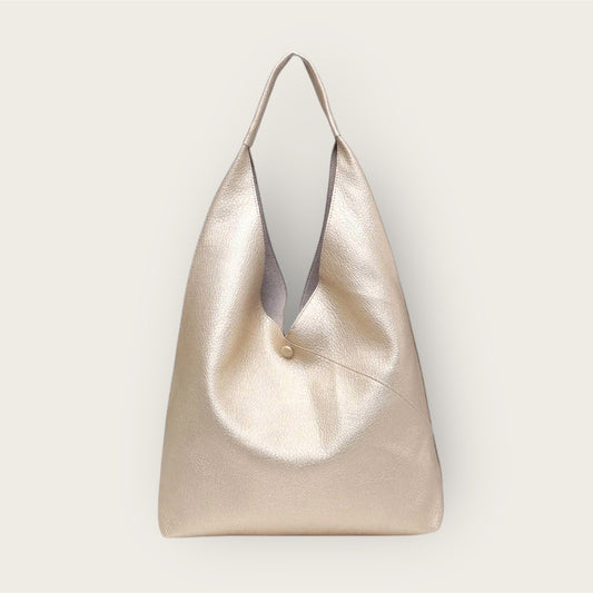 Gold handbag with a subtle texture on a light gray background