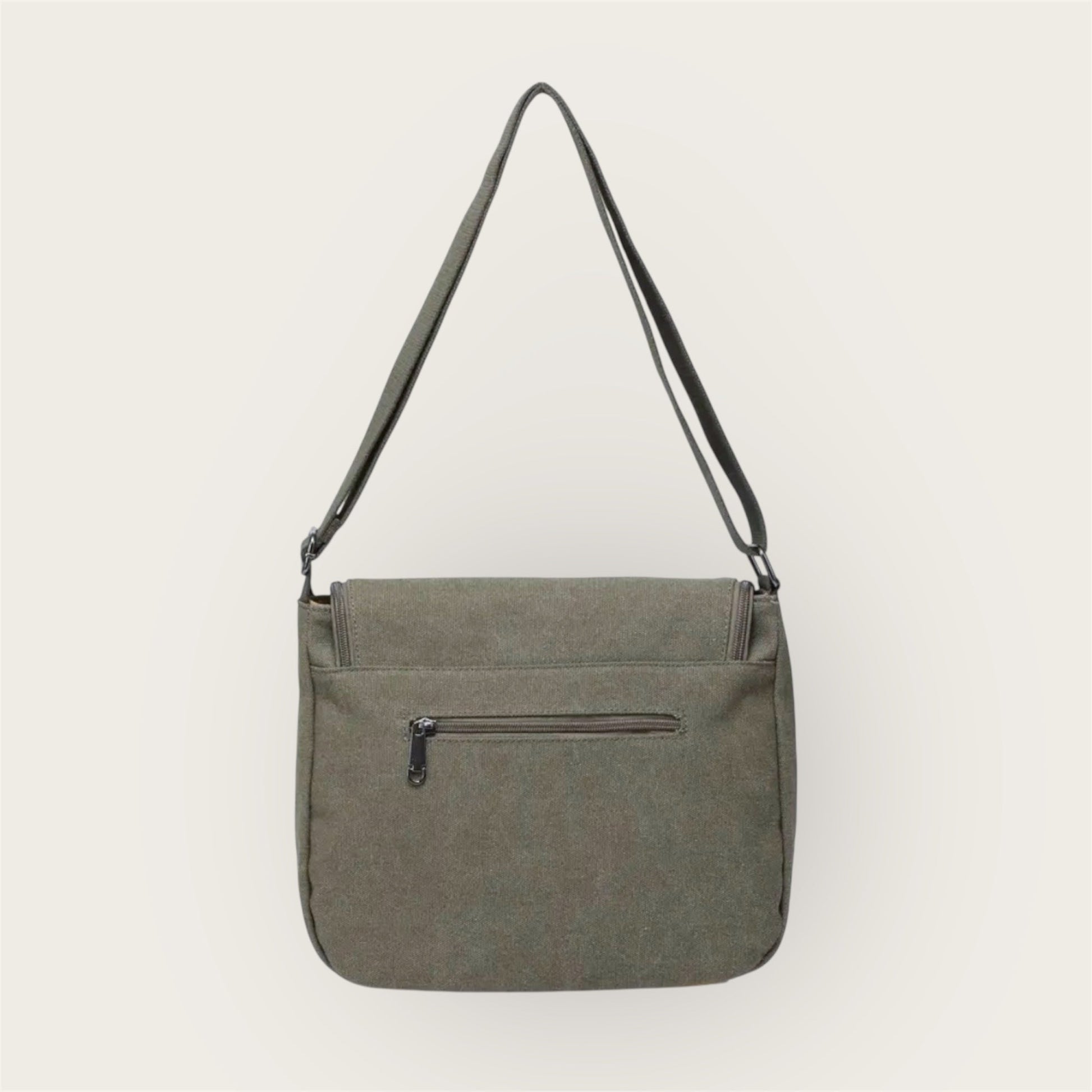 Back of green shoulder bag with a zipper on a white background
