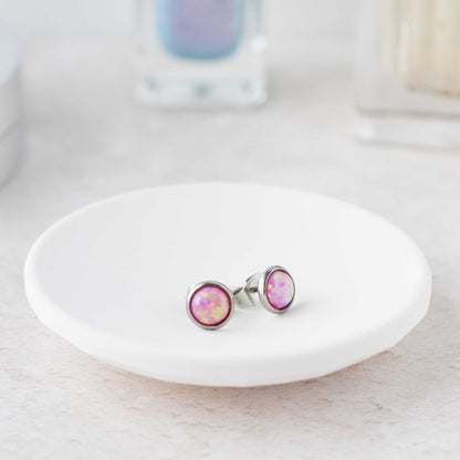 Pink earrings on a white dish with a blurred background