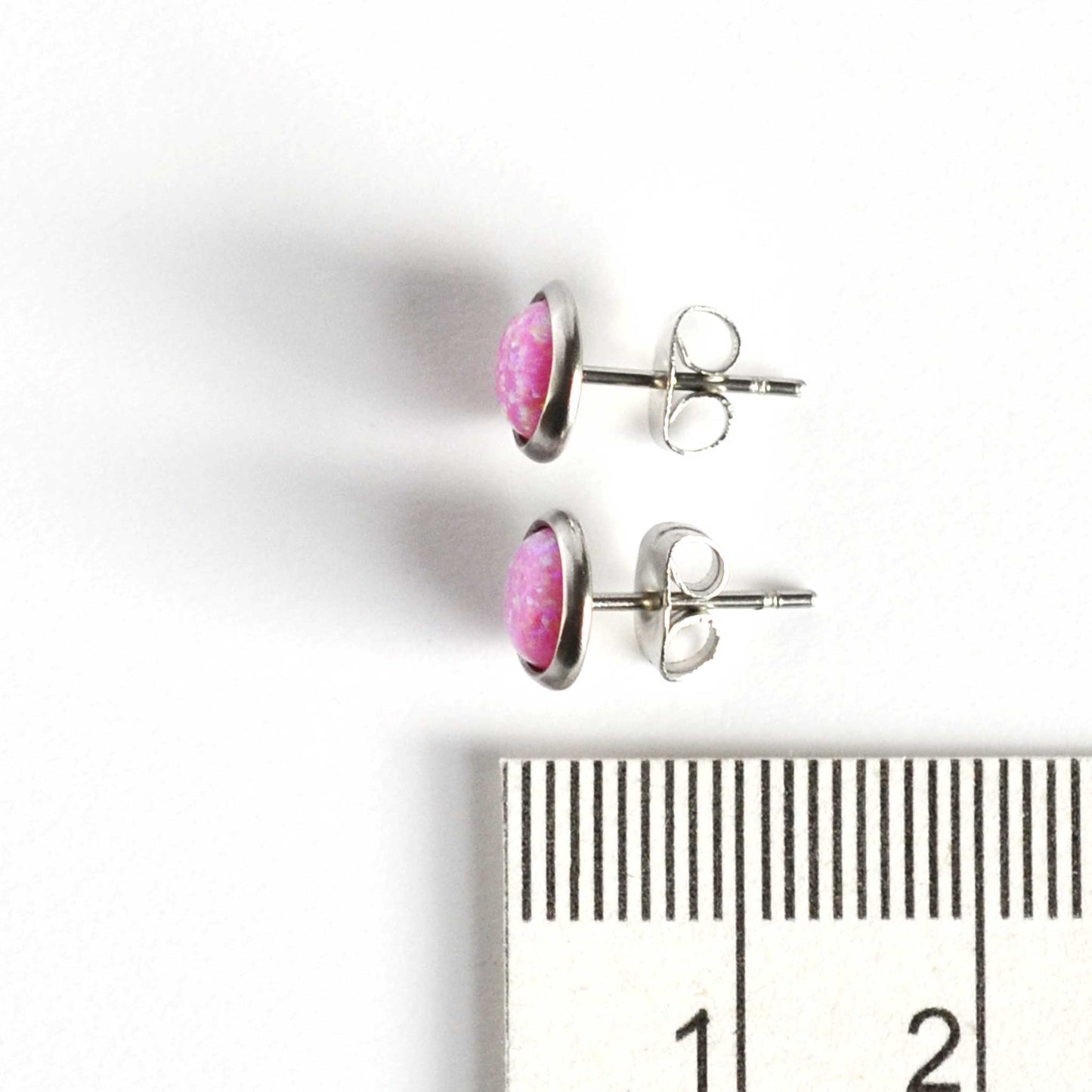 Pink Opal stud earrings next to ruler
