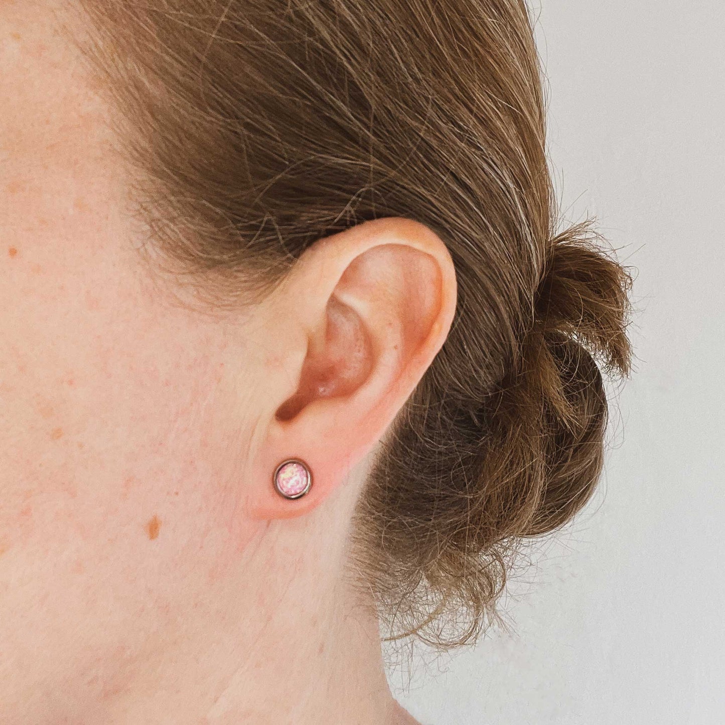 Woman wearing pink Opal stud earring in earlobe
