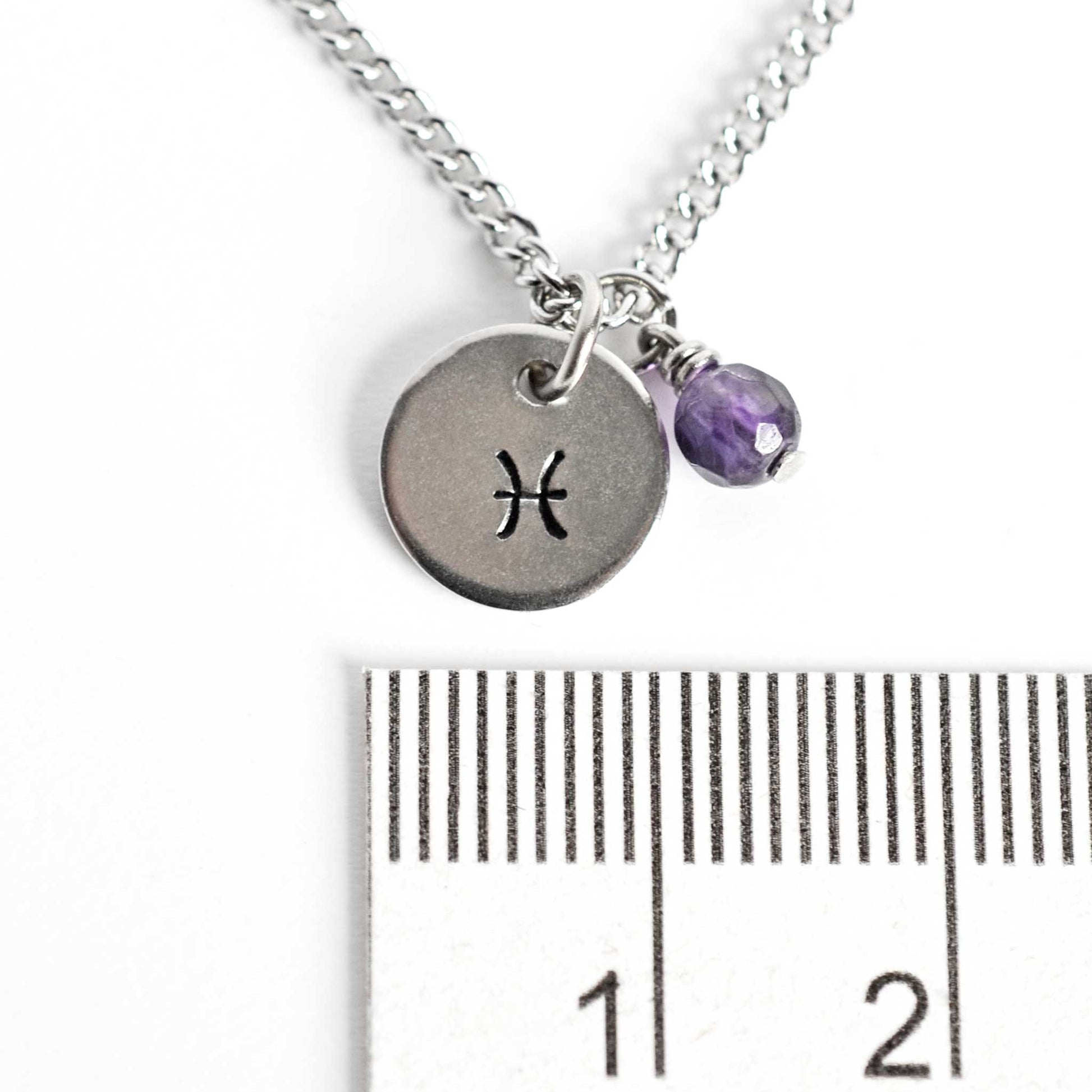 1cm diameter disc pendant with hand stamped Pisces zodiac sign and 4mm Amethyst gemstone charm