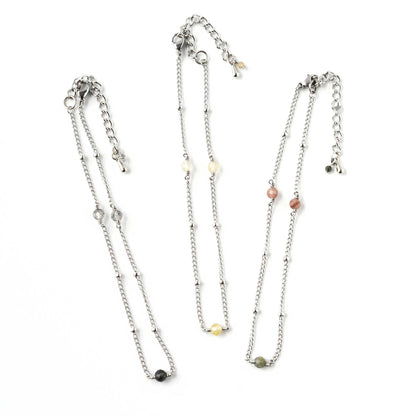 Three ankles with different coloured gemstone accent beads on white background.