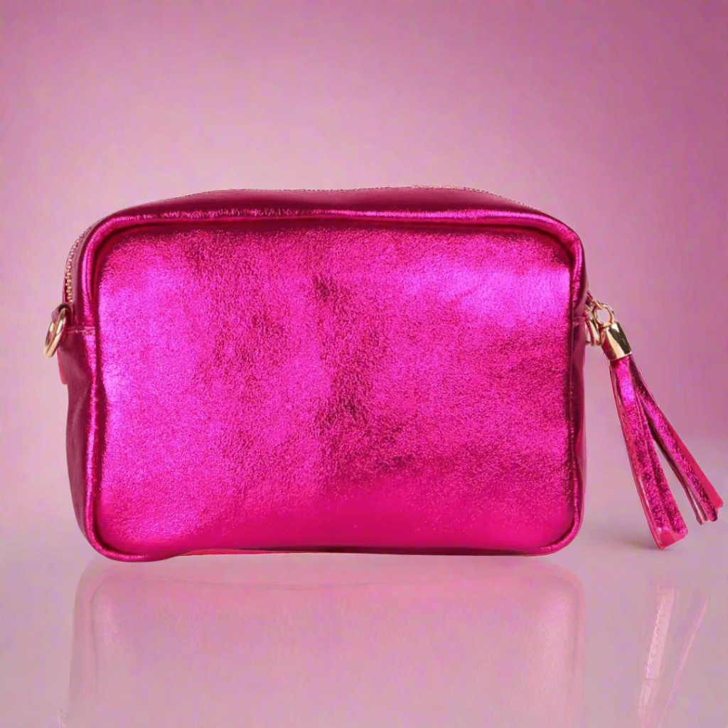 Pink metallic handbag with gold accents on a pink background