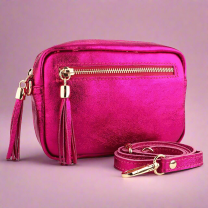 Pink handbag with gold accents on a light pink background