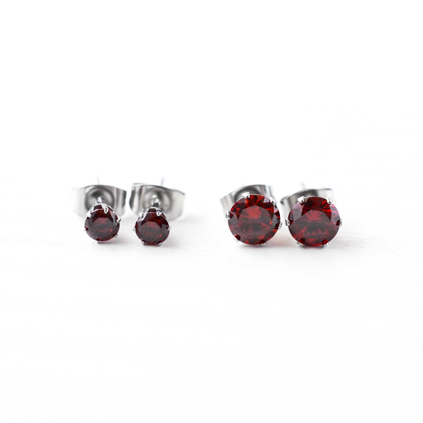 4mm & 6mm red cubic zirconia stud earrings on white background.