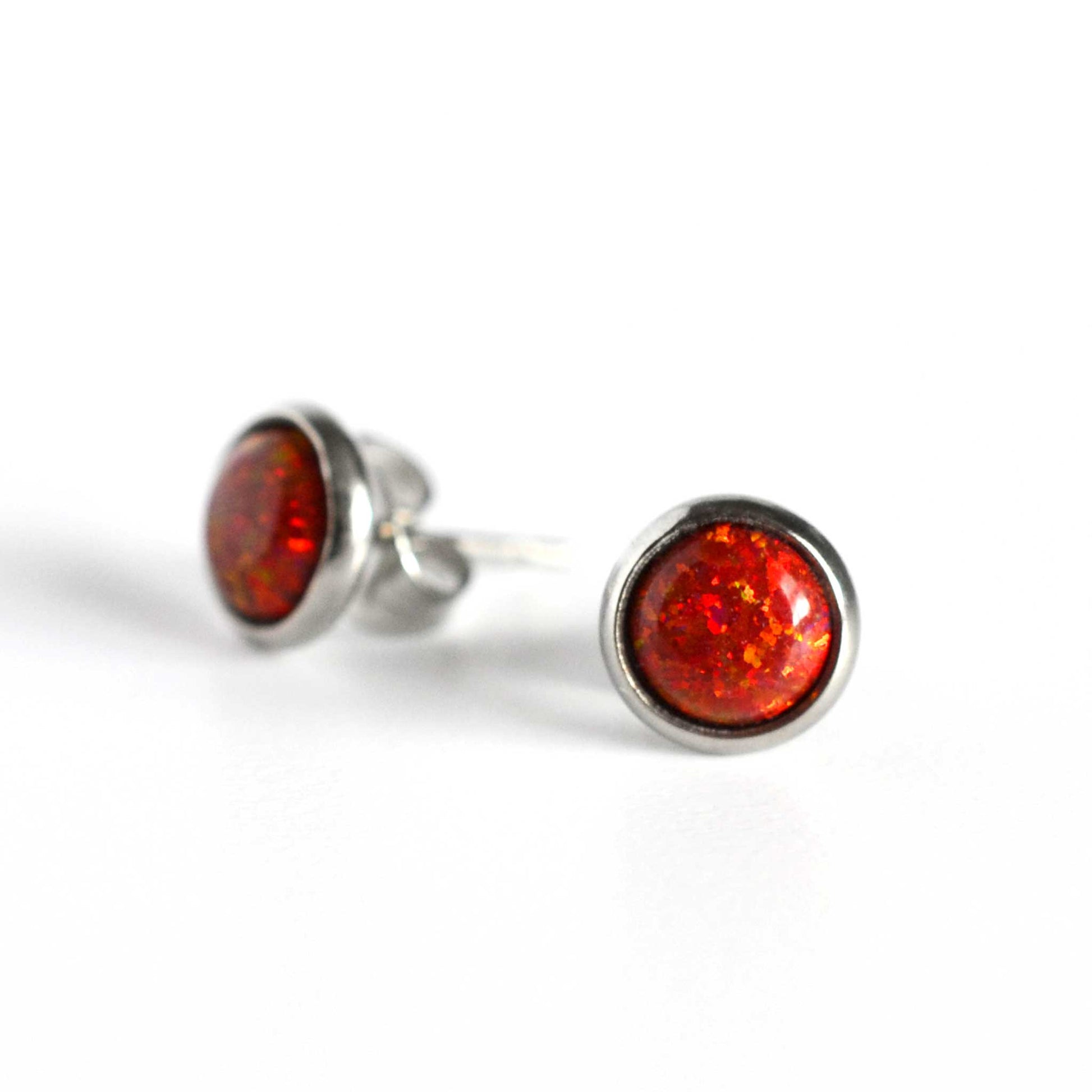 Pair of red Opal stud earrings on white background