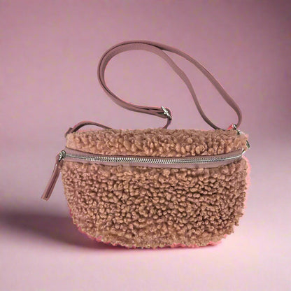 Brown fluffy handbag with a pinkish-purple background