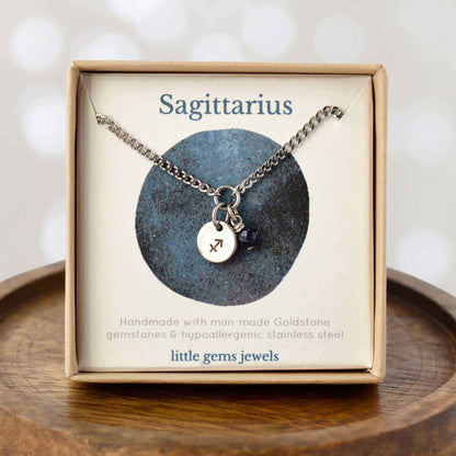 Dainty Sagittarius zodiac sign necklace in eco-friendly gift box on wooden coaster