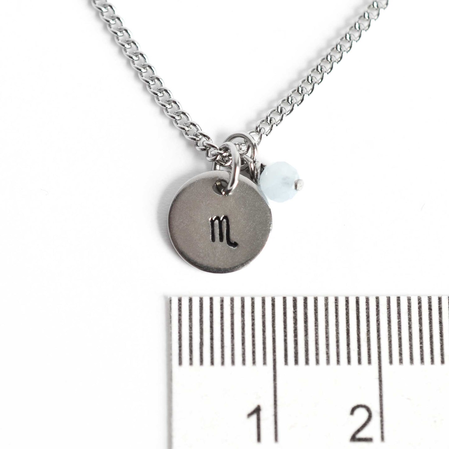 1cm diameter disc pendant with hand stamped Scorpio zodiac sign and 4mm Aquamarine gemstone charm