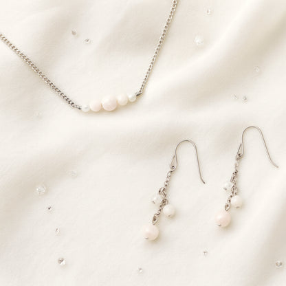 Pale pink gemstone necklace and earrings on a light background