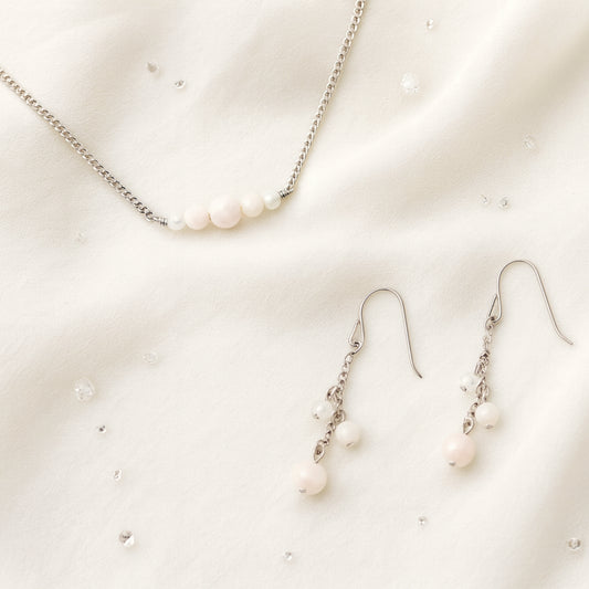 Pale pink gemstone necklace and earrings on a light background