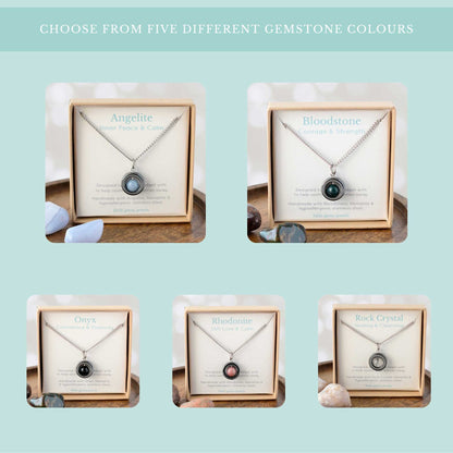 Choose from five different gemstone colours graphic showing Angelite, Bloodstone, Onyx, Rhodonite & Rock Crystal spinner necklaces on their gemstone meaning cards in gift boxes.
