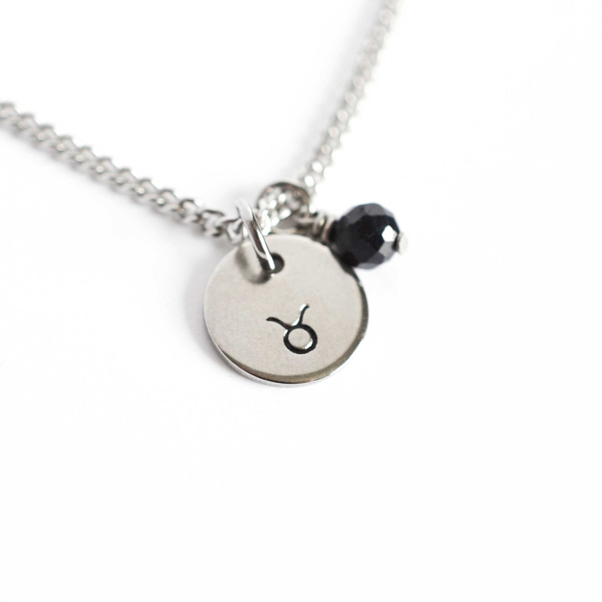 Taurus Zodiac pendant necklace with tiny Sapphire gemstone charm on white background