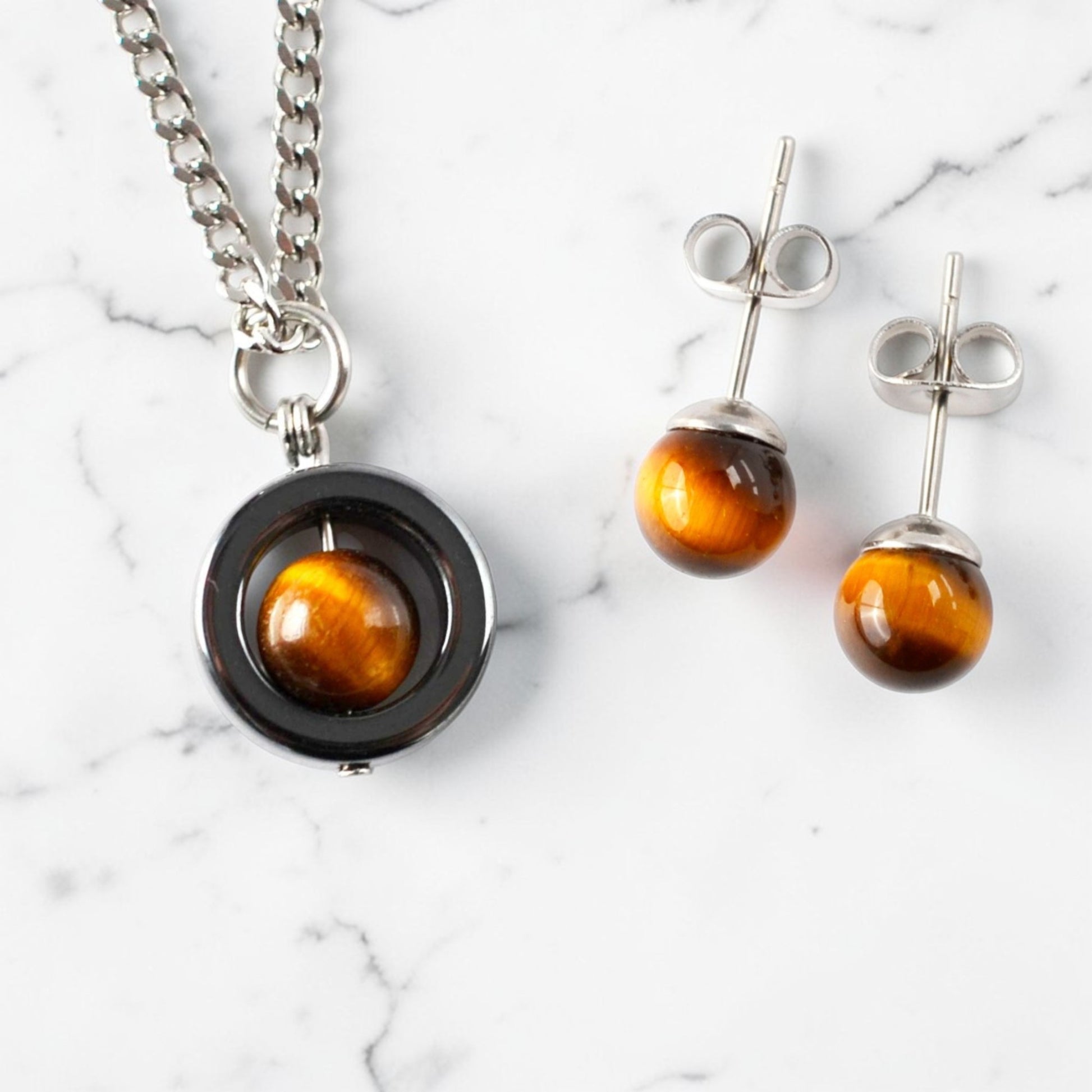 Tigers Eye necklace and stud earring set on a marble surface