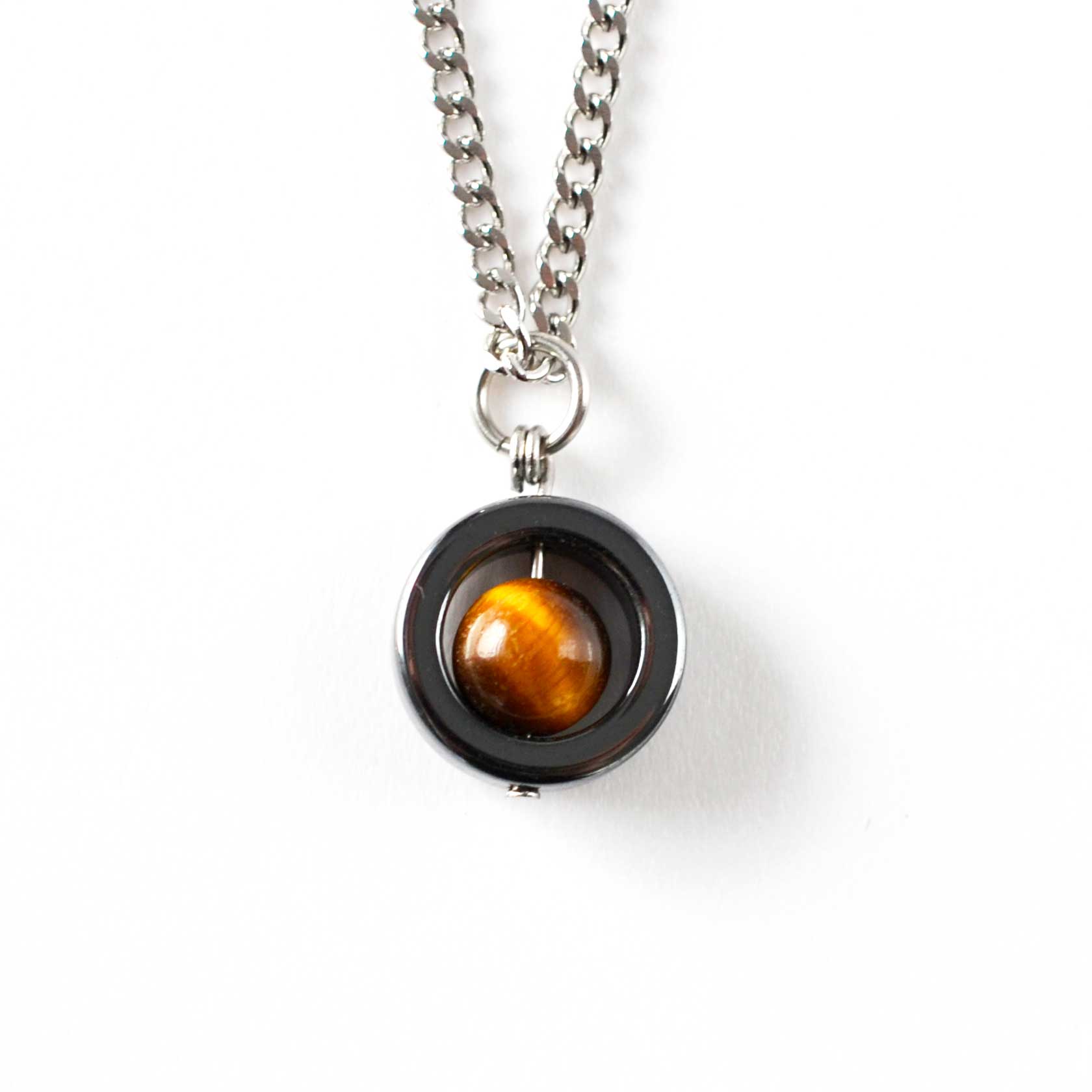 Hematite spinner pendant featuring a tiger's eye stone on a white background