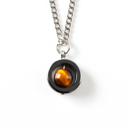 Hematite spinner pendant featuring a tiger's eye stone on a white background