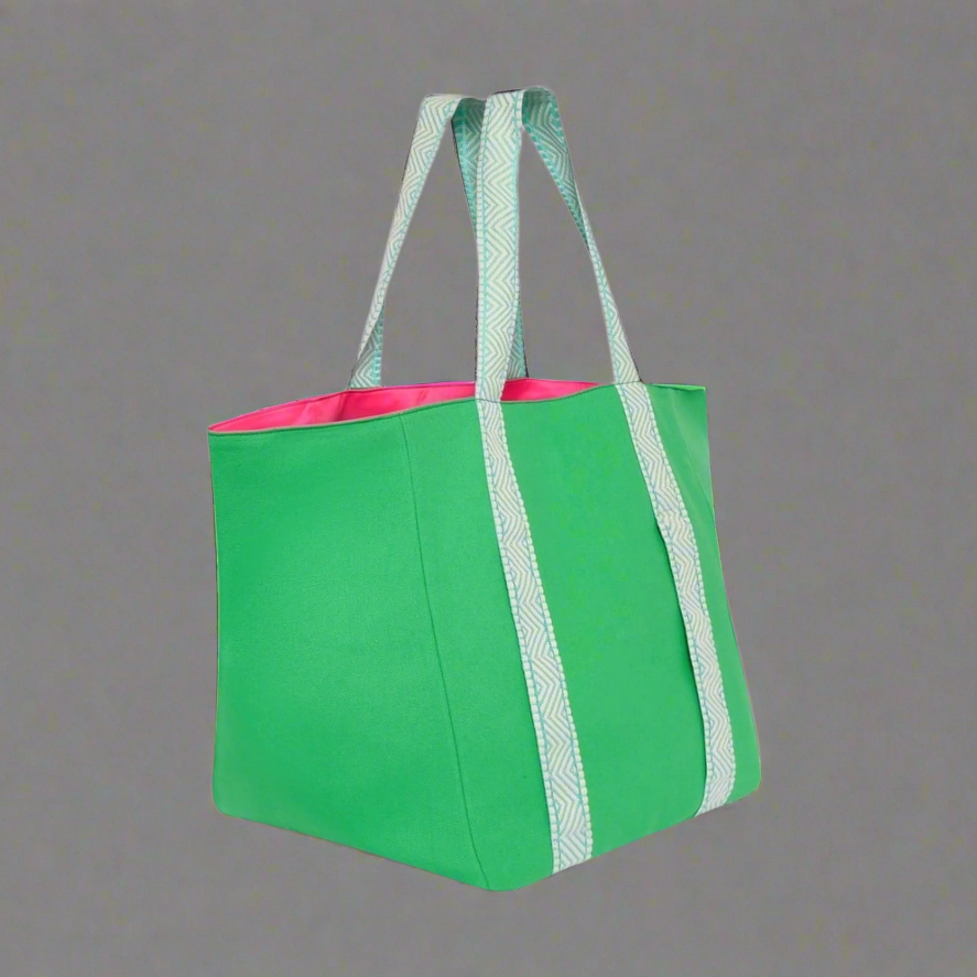 Green tote bag with white handles on a gray background