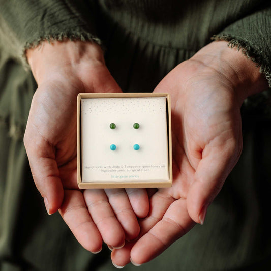 Woman's hands holding a gift box with a set of Jade and Turquoise stud earrings.