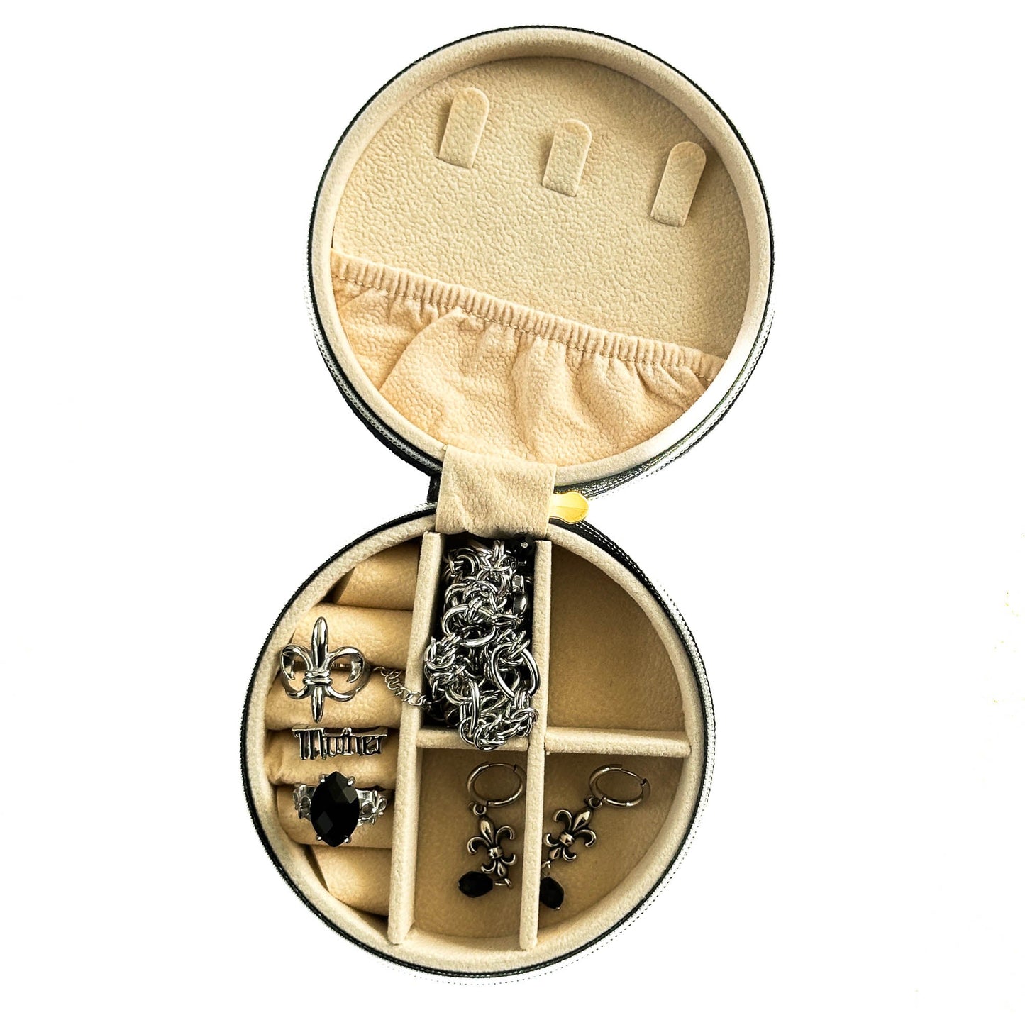 Round jewelry box with compartments containing various earrings on a white background