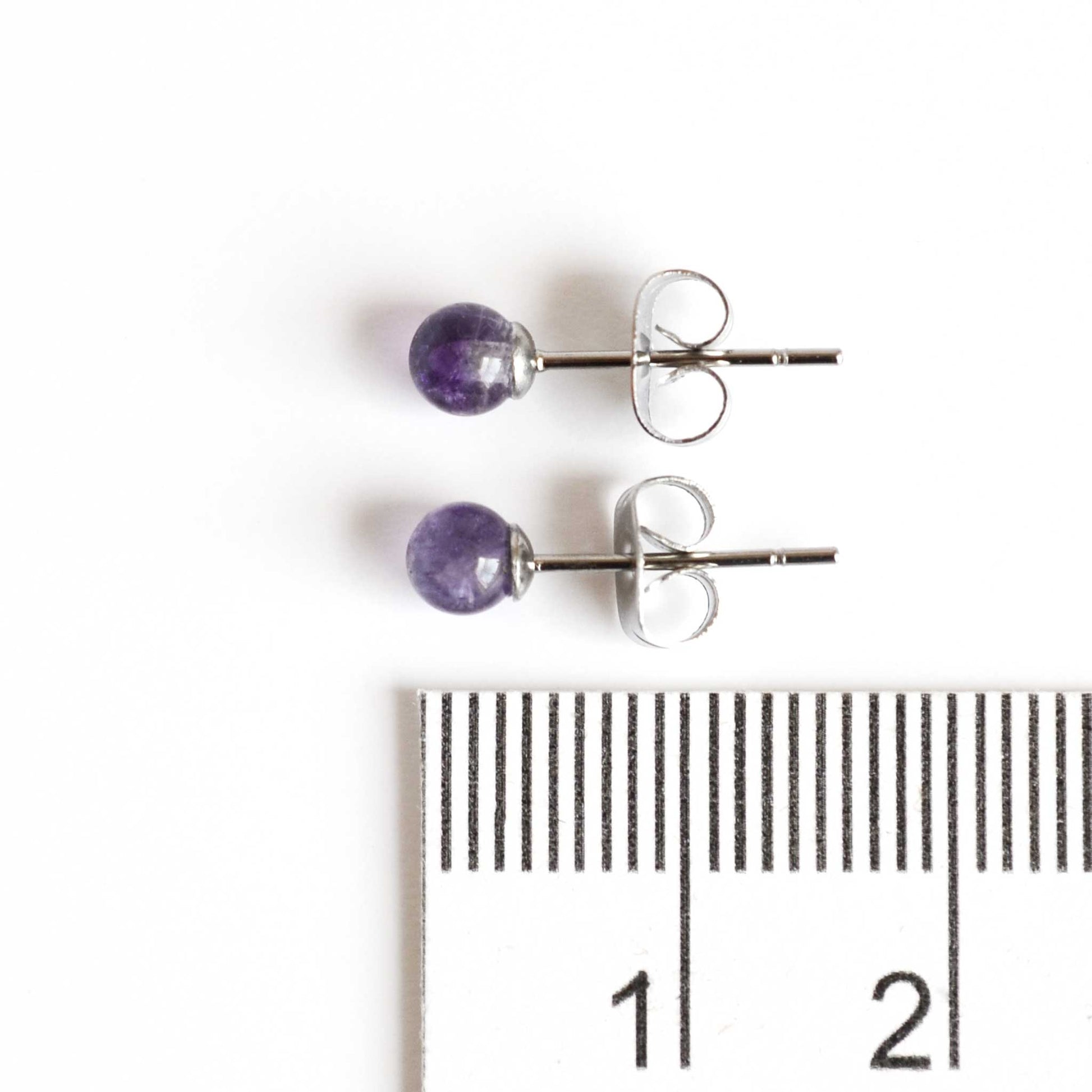 4mm Amethyst stud earrings next to ruler