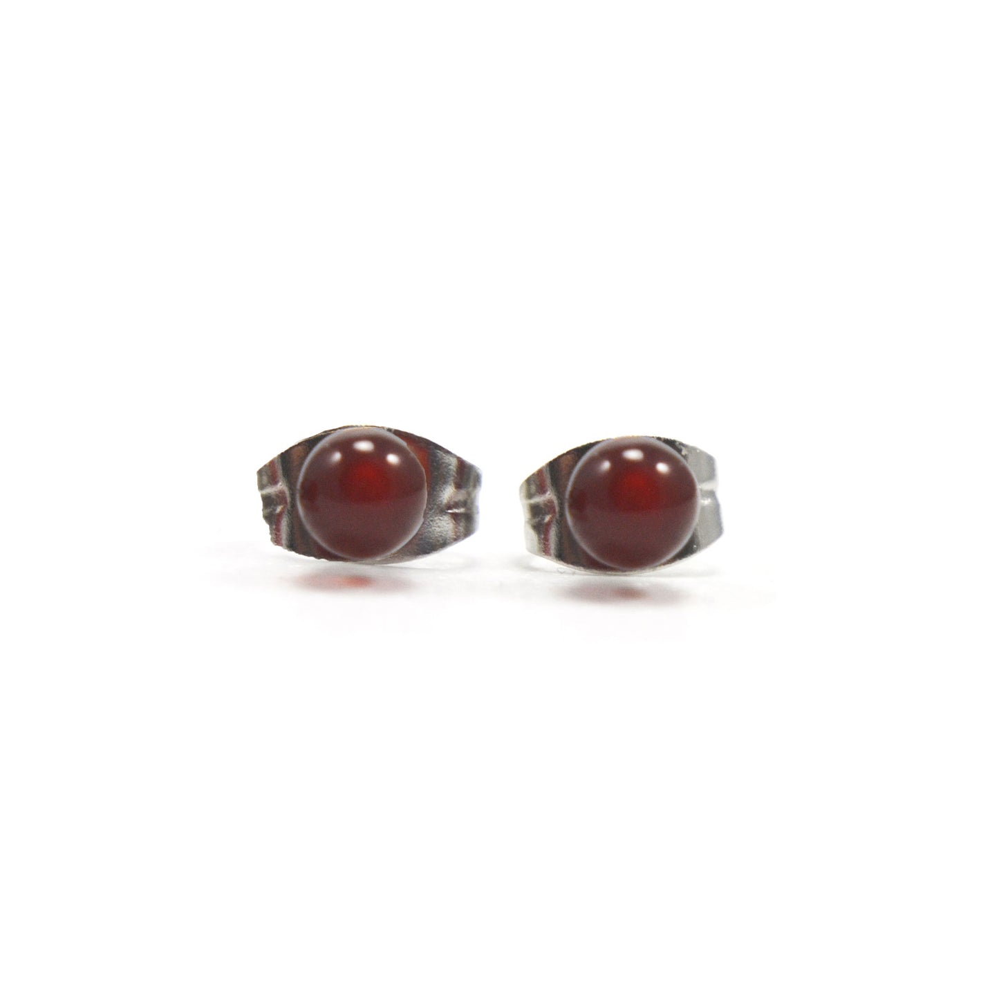 Front view of small orange Carnelian studs on white background