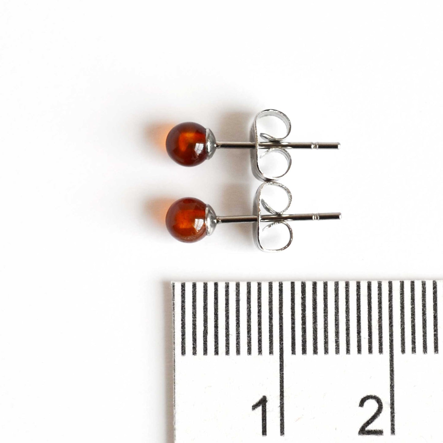 4mm Carnelian stud earrings next to ruler