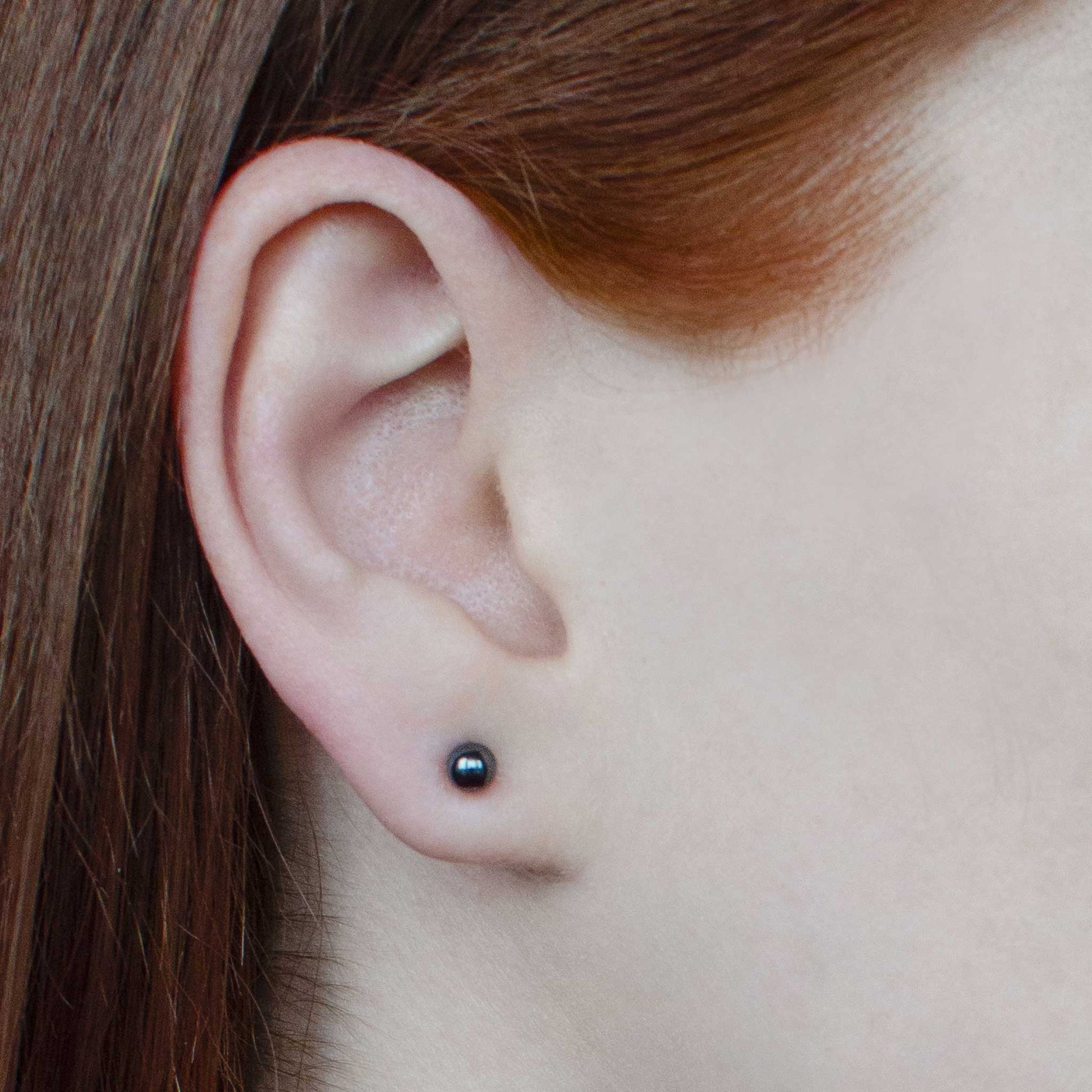 Woman wearing small hematite earrings stud in earlobe