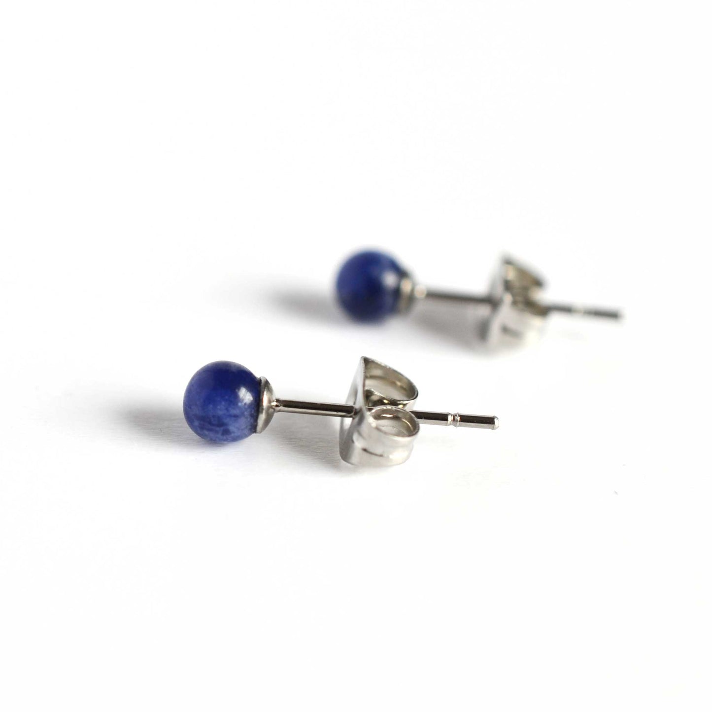 Side view of small blue stud earrings with Sodalite gemstones and surgical steel posts