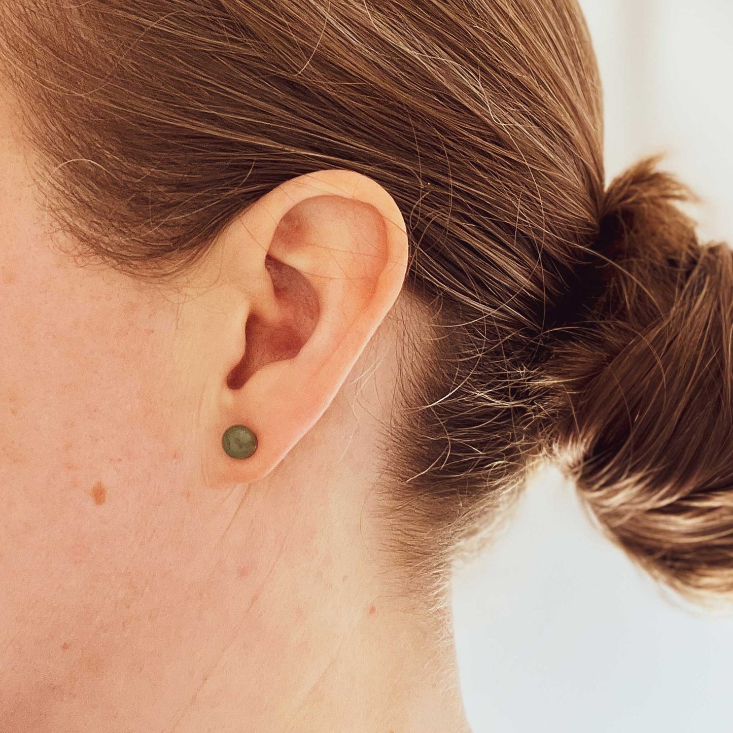 Woman wearing Green Aventurine earring stud in earlobe