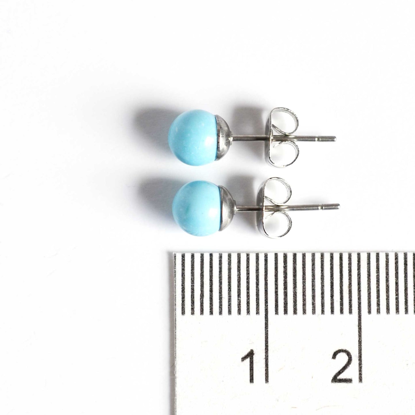 6mm Turquoise earrings studs next to ruler