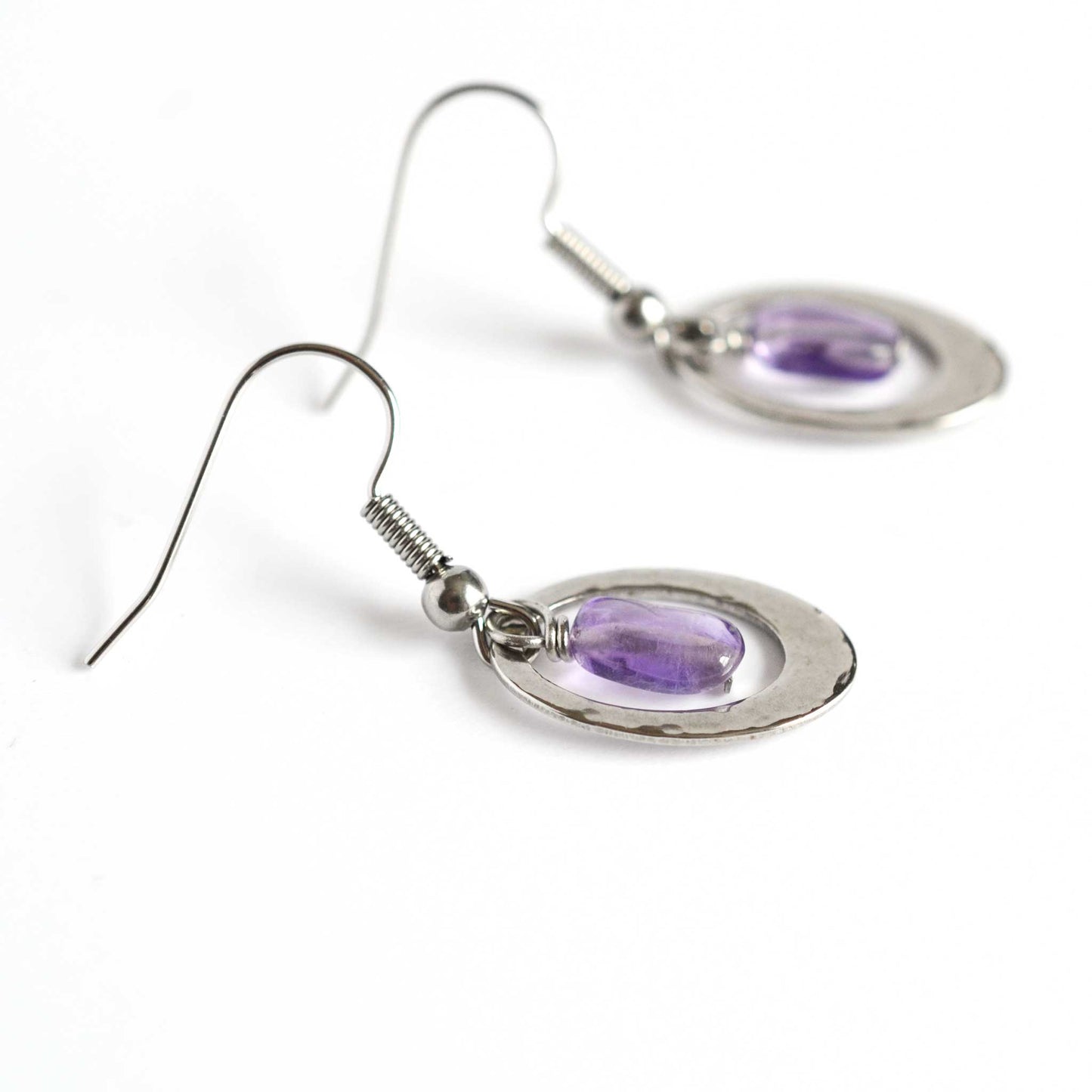 Side view detail of Amethyst oval drop earrings with surgical steel hook.