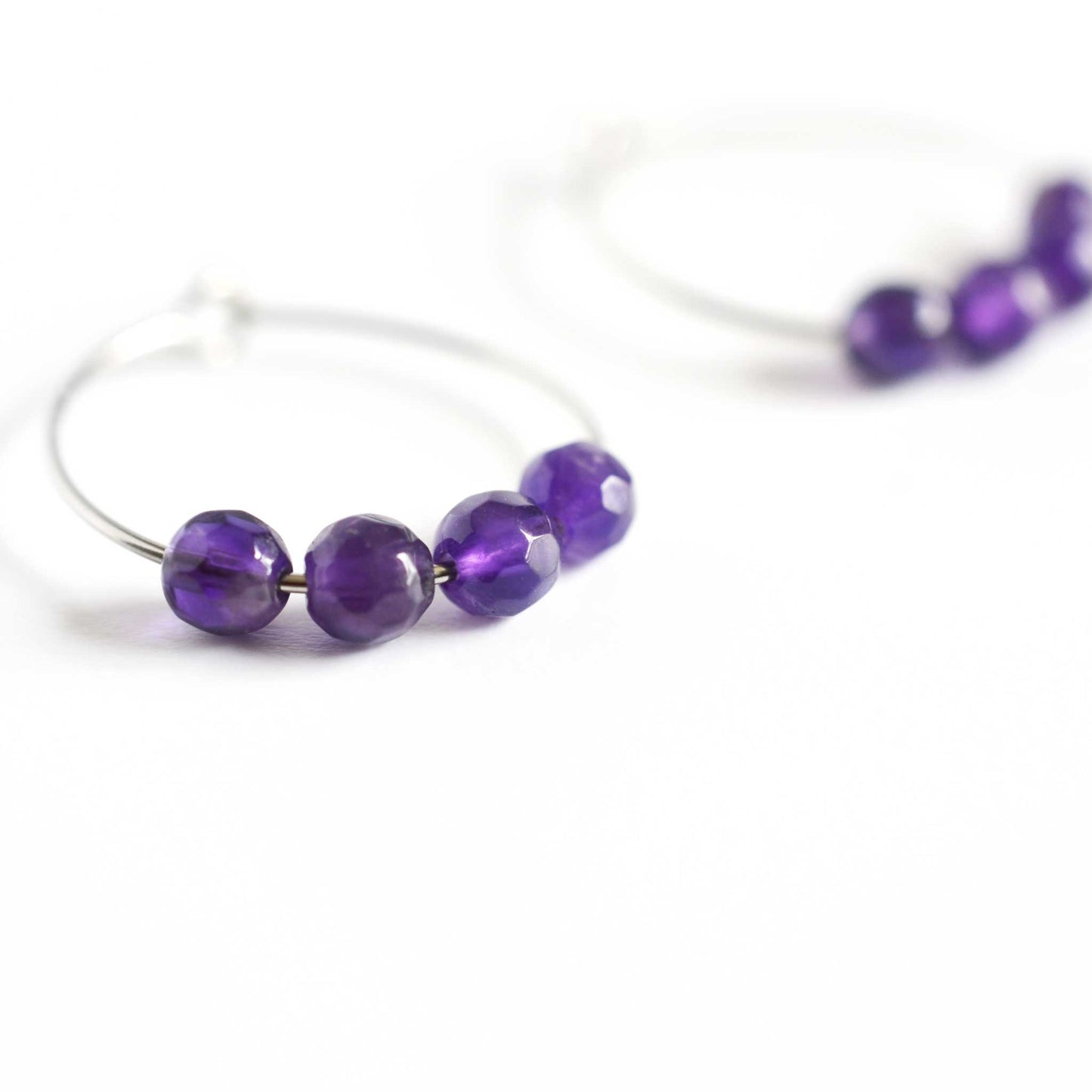 Close up of Amethyst hoop earrings with four small round faceted purple Amethyst gemstone beads 
