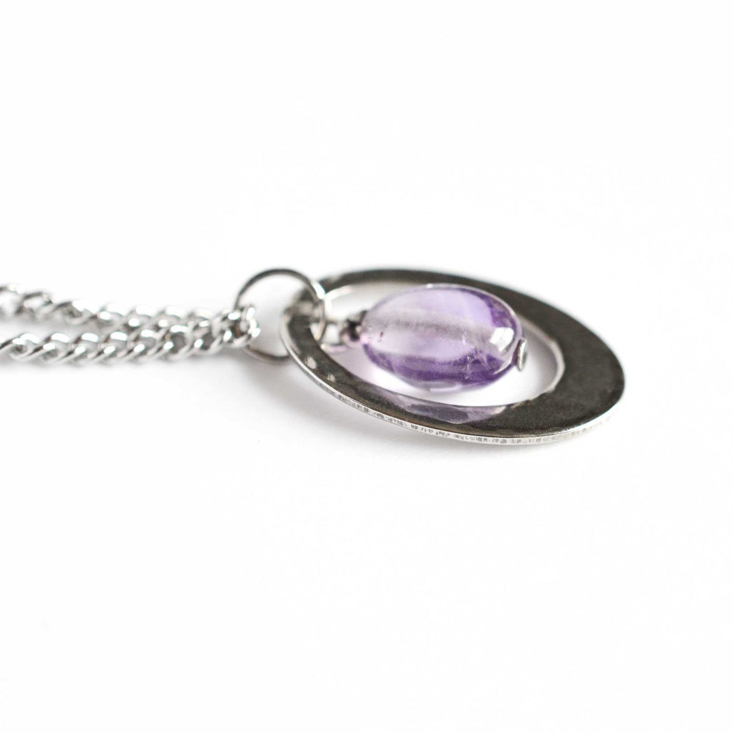 Close up view of Amethyst oval pendant necklace on stainless steel curb chain.