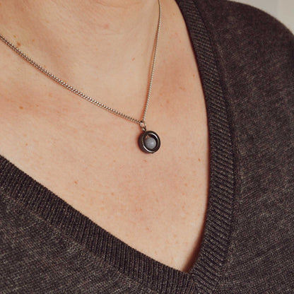 Model wearing grey v neck jumper and light blue Angelite gemstone fidget necklace.