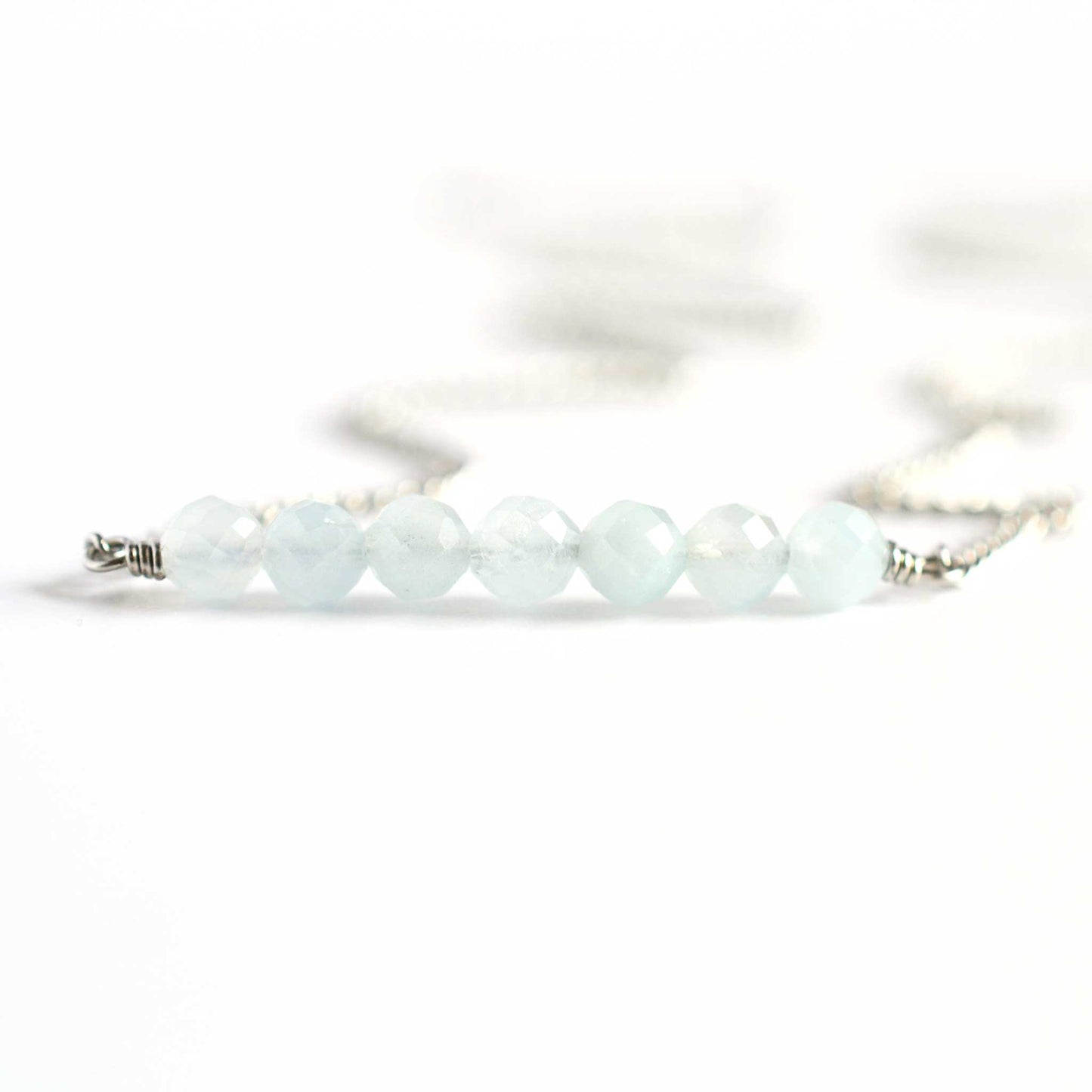 Close up of Aquamarine necklace with seven small round faceted pale blue Aquamarine gemstones