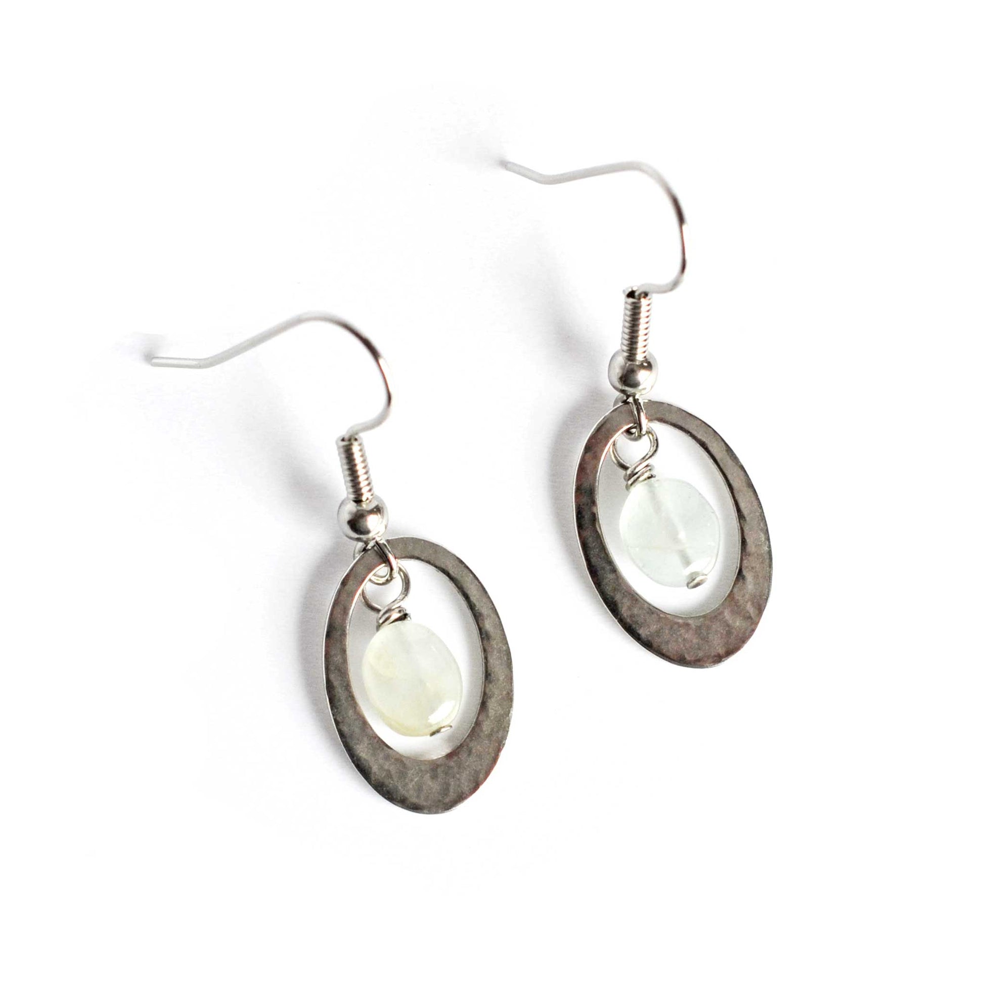 Oval drop earrings with central Aquamarine gemstone on white background.