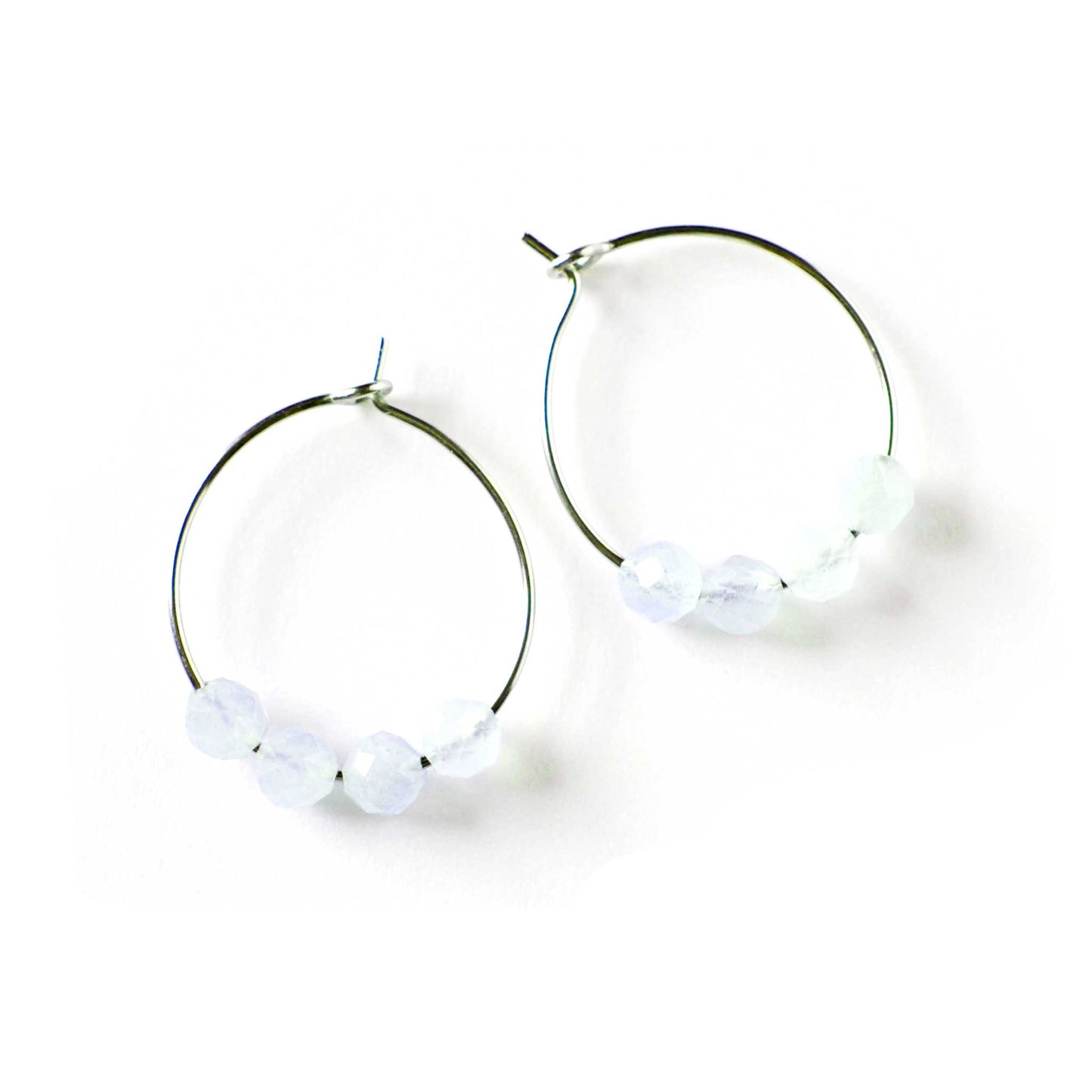 Pair of pale blue Aquamarine hoop earrings on white background