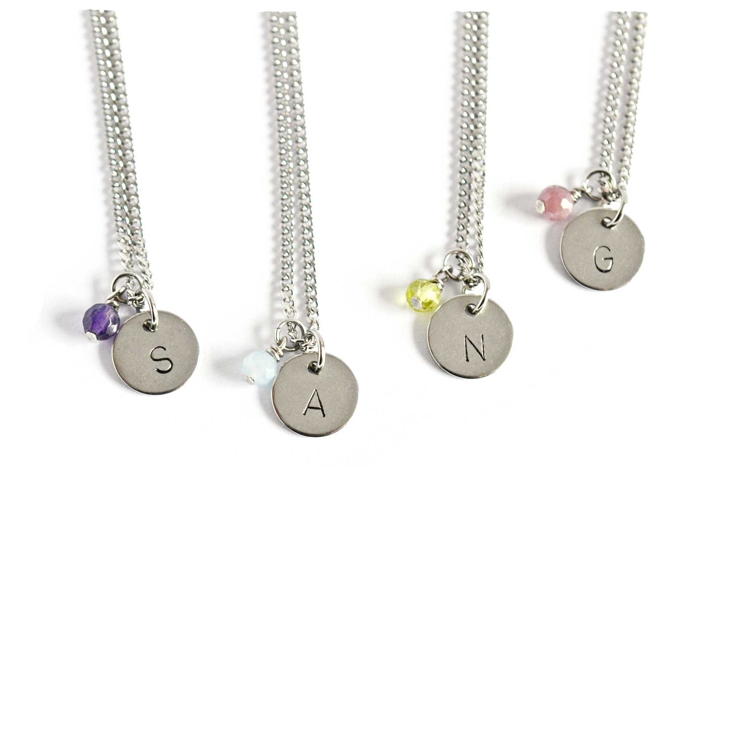 Birthstone necklaces with initial charm on white background