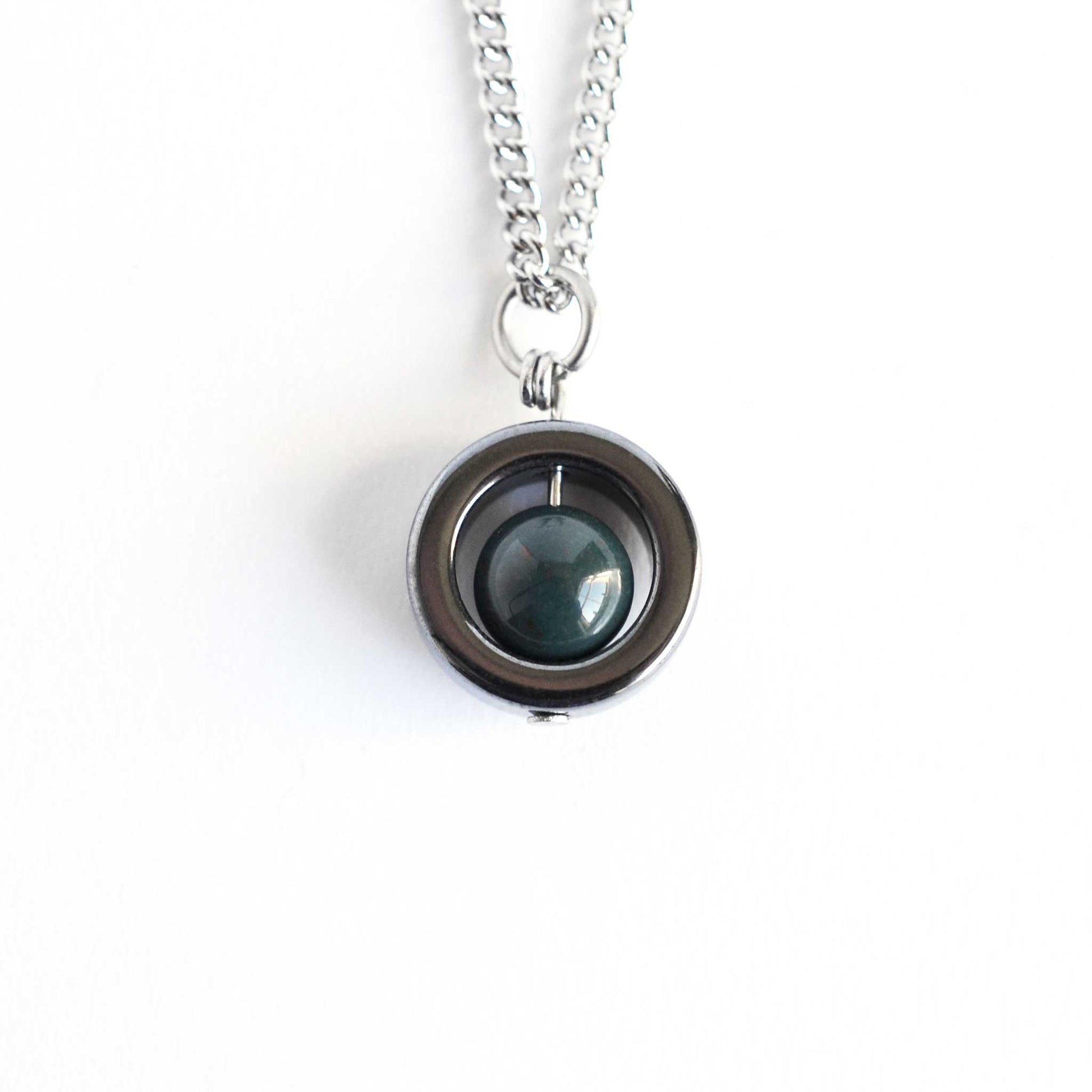 Hematite and green Bloodstone spinner necklace on white background.