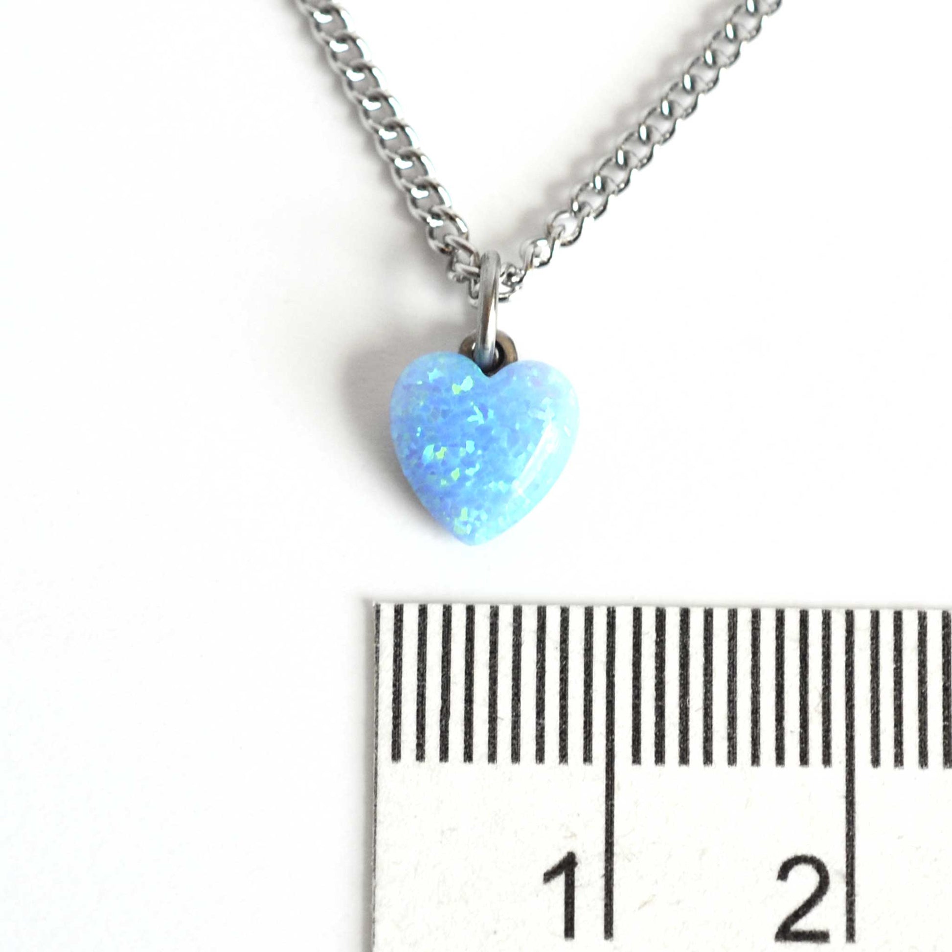 8mm blue heart pendant necklace next to ruler