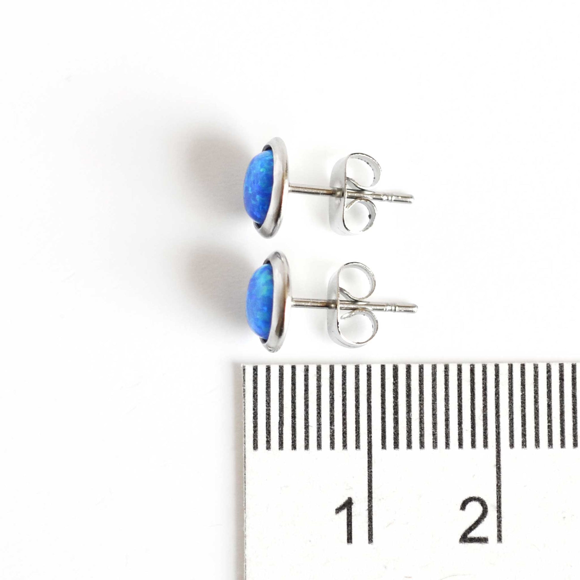 8mm blue Opal earrings next to ruler