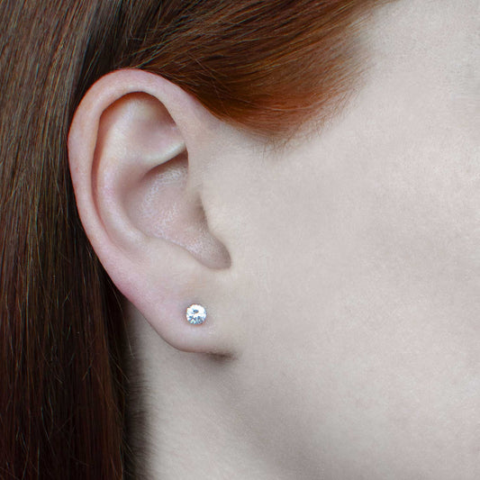 Woman wearing small stud Cubic Zirconia earrings in earlobe